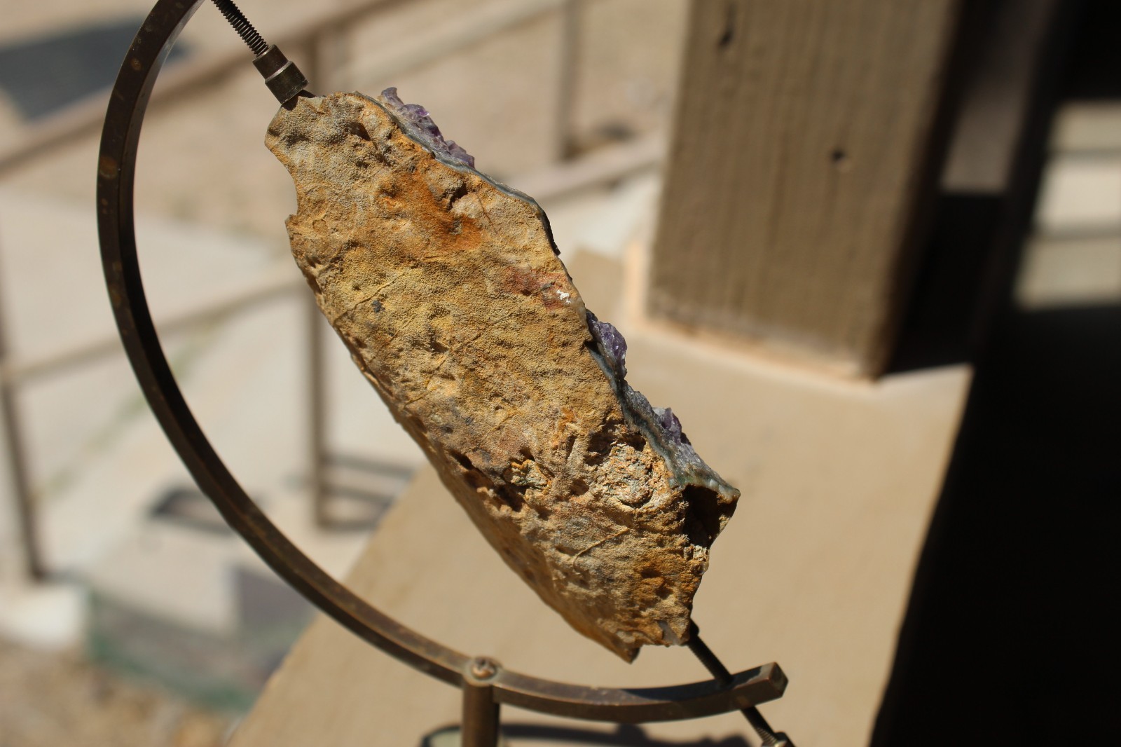 Amethyst geode specimen with brass holder