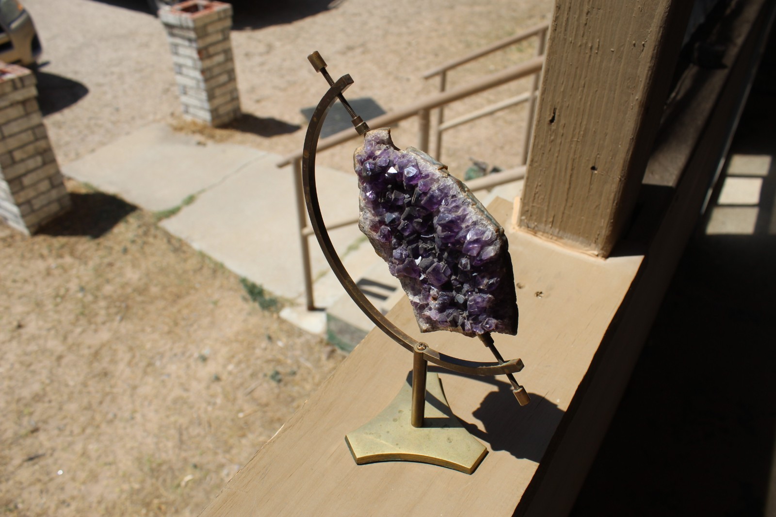 Amethyst geode specimen with brass holder