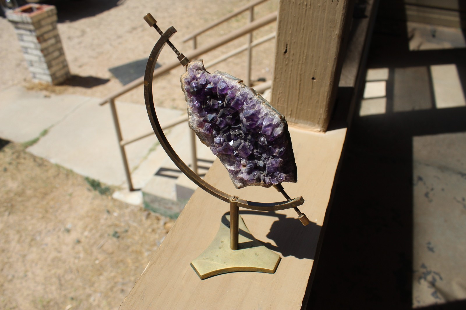Amethyst geode specimen with brass holder