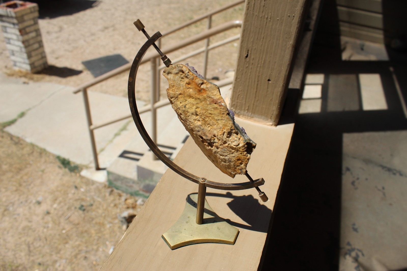 Amethyst geode specimen with brass holder
