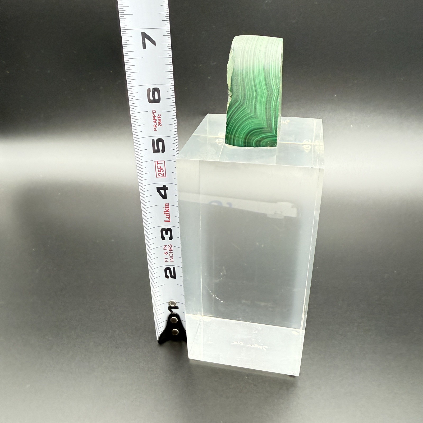 Dark green banded malachite on a lucite Base artist Unknown Signed – “?” Ax