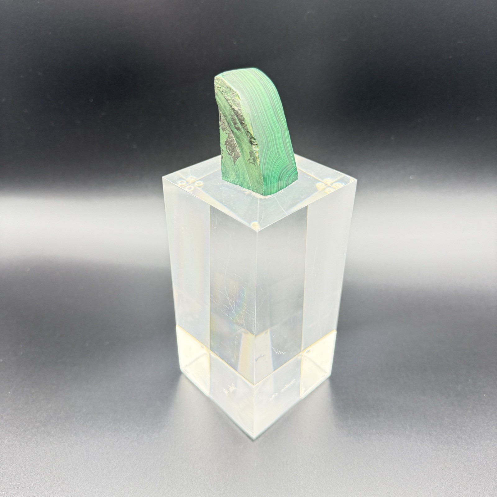 Dark green banded malachite on a lucite Base artist Unknown Signed – “?” Ax