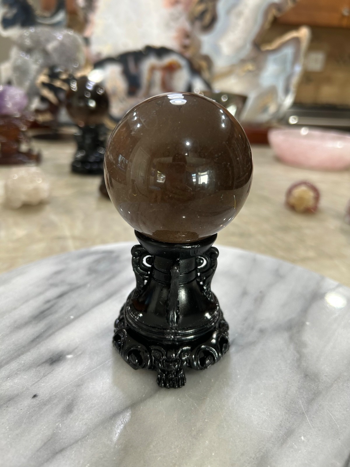 Smoky quartz rutile sphere on resin stand 2.47”