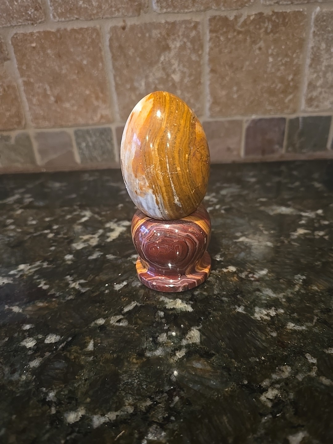 Polished Banded Onyx Egg On A marble Stand