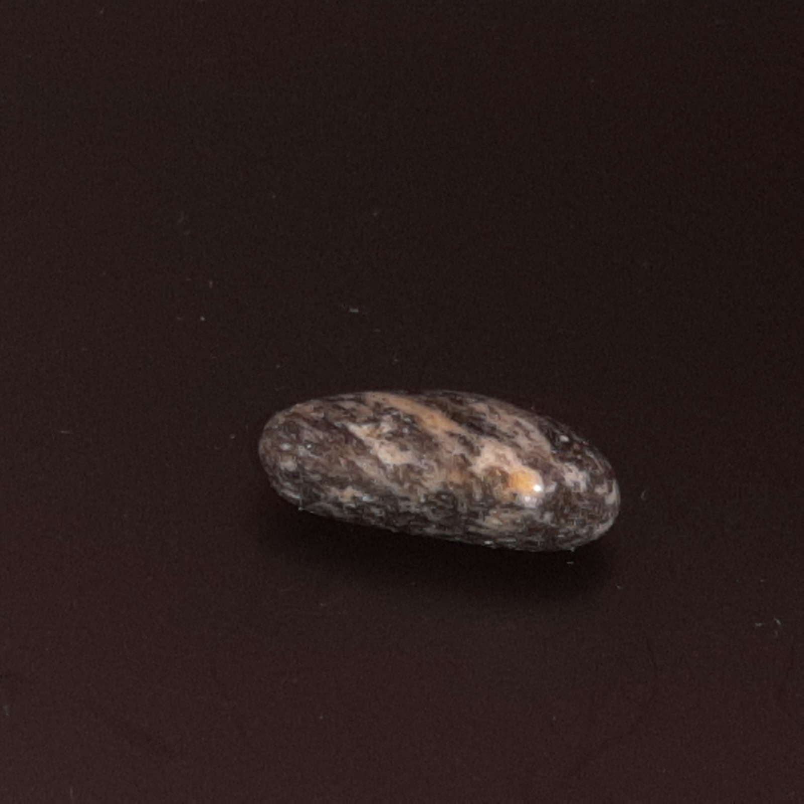 Polished Granite Black and White with some brown. Oval Shape Approx. 2 cm
